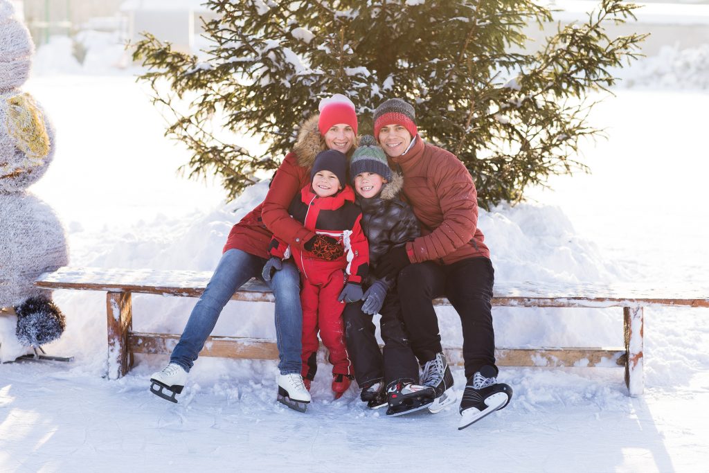 Beautiful family walking and playing on the ice in winter.