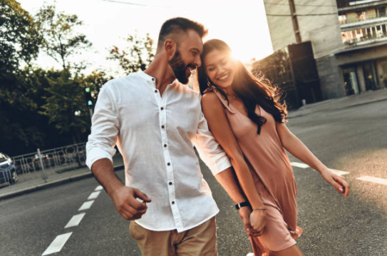 Young couple walking together holding hands | Motif