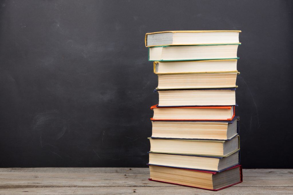 Education concept - books on the desk in the auditorium