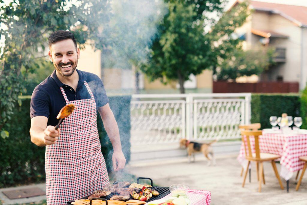 Photography of a man cooking food on a grill | Motif