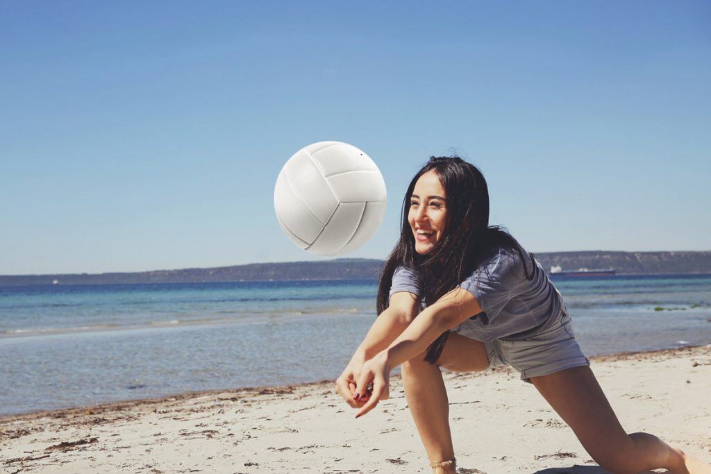 A woman playing beach volleyball | Motif