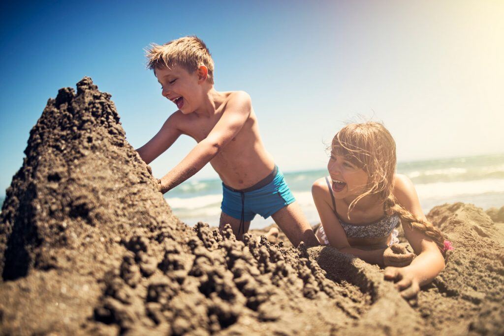 Brother and sister building a sandcastle | Motif