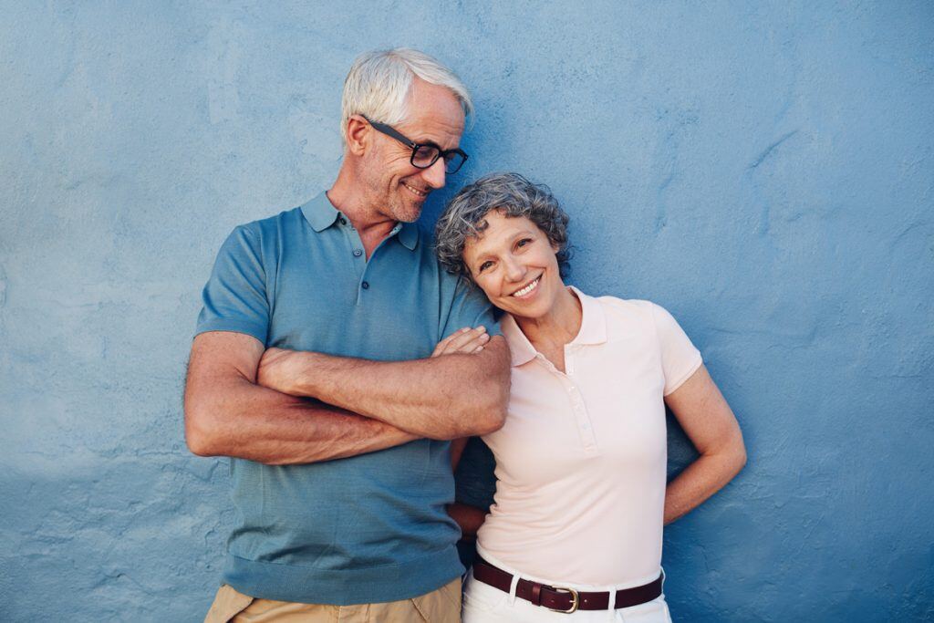 A couple taking a picture against a blue wall | Motif