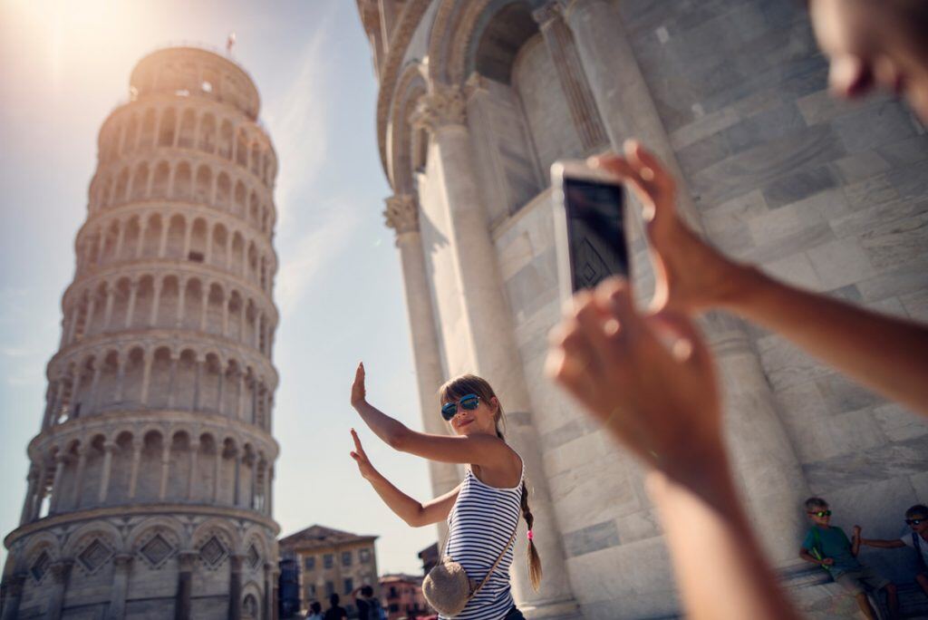 Girl pretending to hold up the leaning tower of Pisa