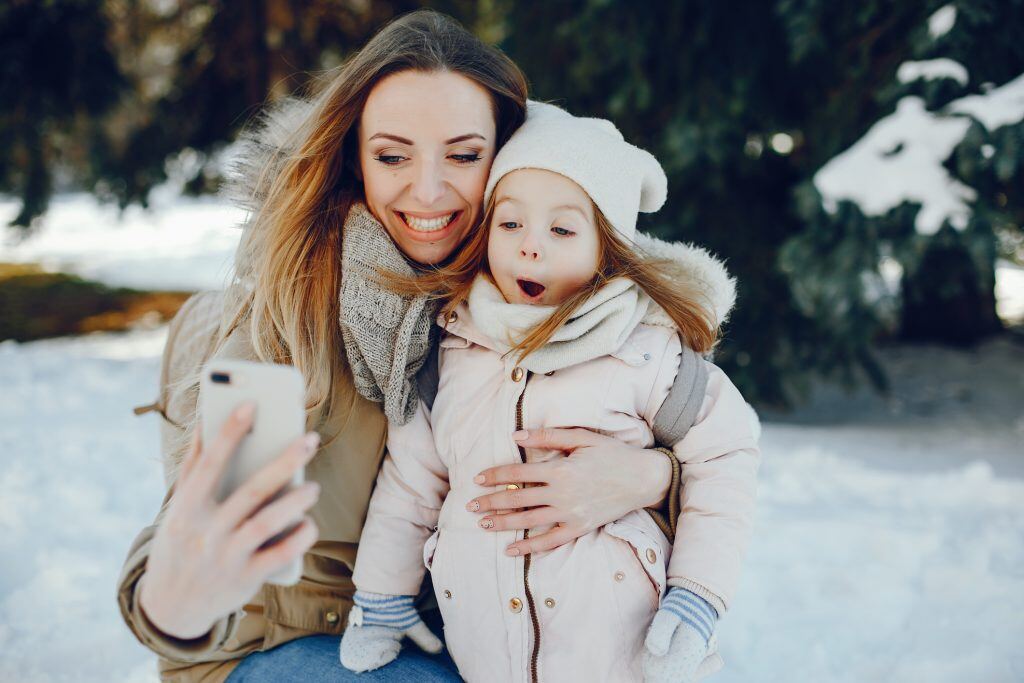 Mom and daughter using snow photography tips to capture memories | Motif