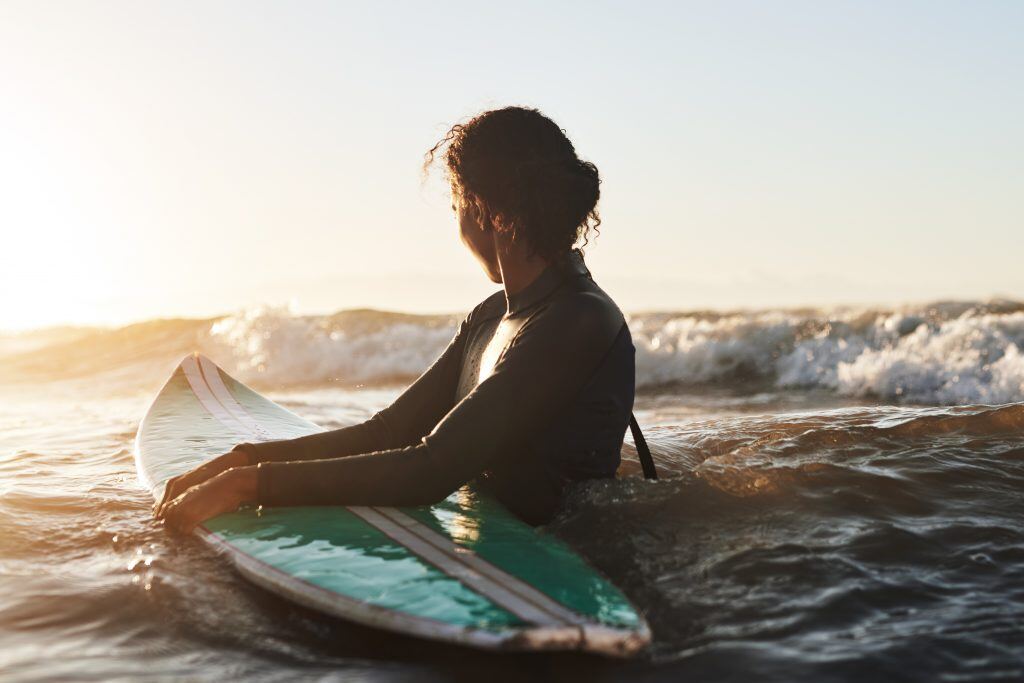 Get in the water with a surfer catching waves to stay cool while taking summer photos.