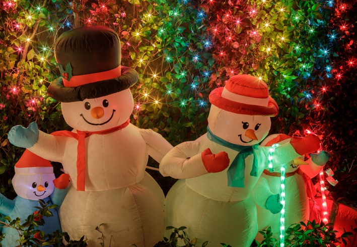 Focus on inflatable snowmen in front yard to make your custom Christmas card.