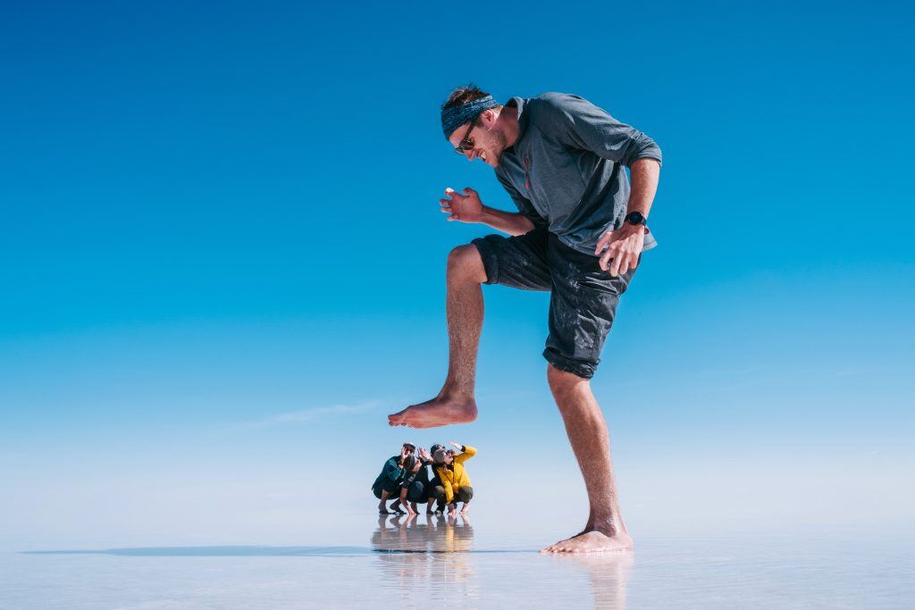 A forced perspective shot of a man "stomping" on his friends like a giant.