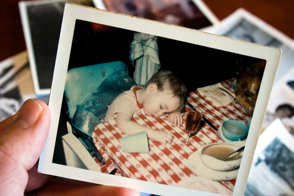 Recreating a childhood photo, where you fell asleep at the dinner table, is a funny selfie idea.