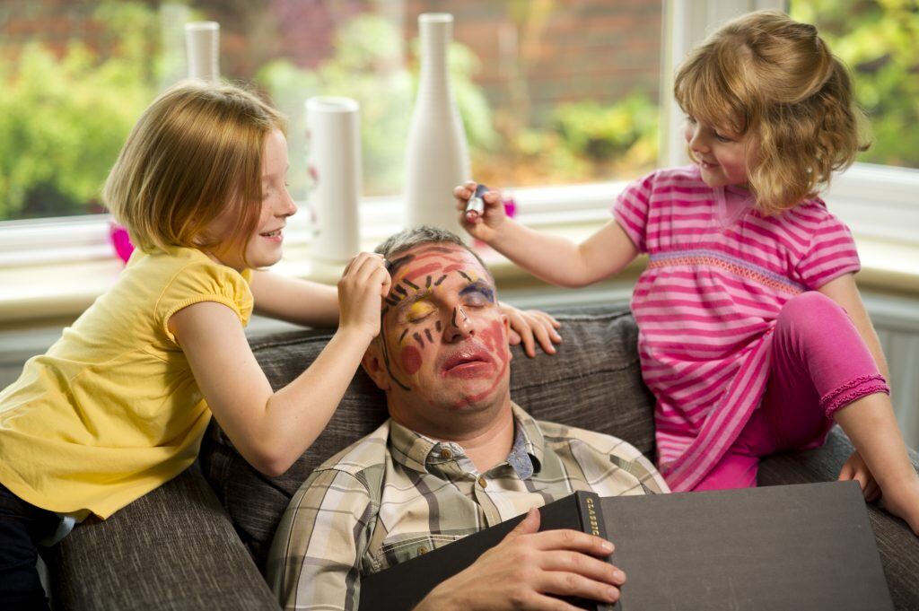 Combine a funny photo book caption with a pic of kids doodling on Dad while he sleeps.