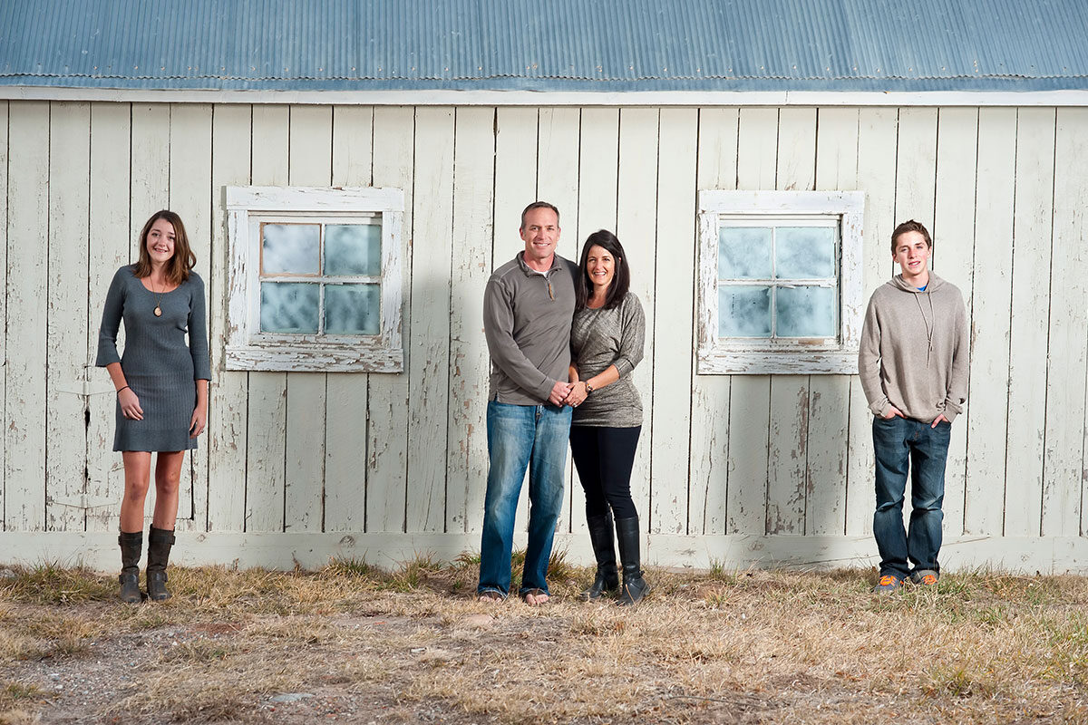 A family photo of parents and kids lining up against the outside of a building | Motif