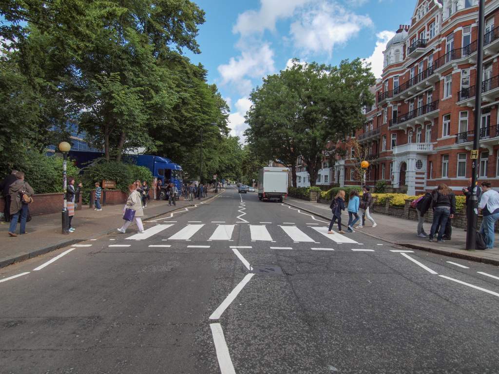 People crossing the Abbey Road zebra crossing made famous by the 1969 Beatles album cover