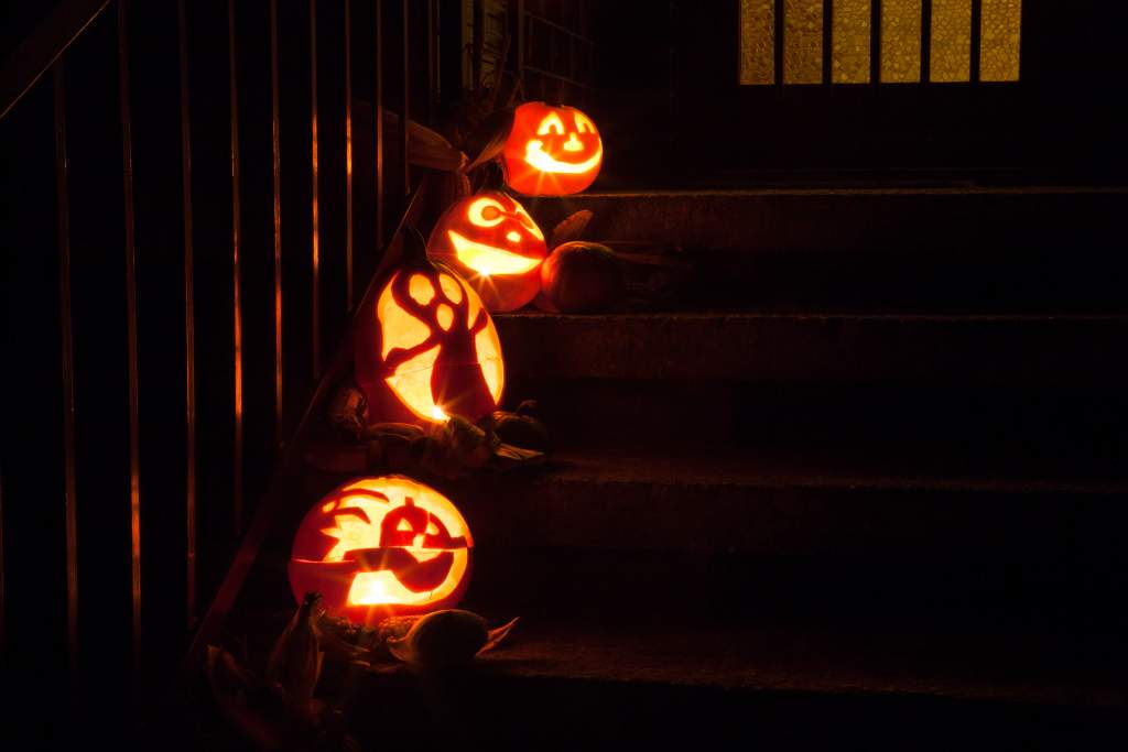 An outdoor staircase with four jack-o-lanterns lit up at night make cute Halloween photos.