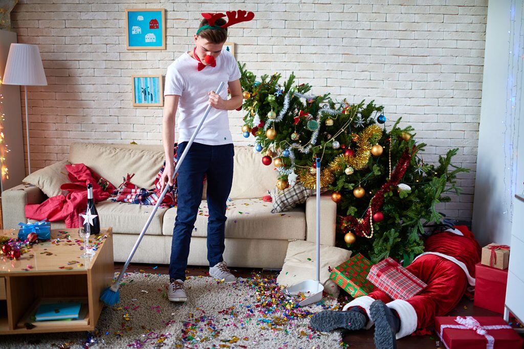 A guy cleaning up after a Christmas party | Motif