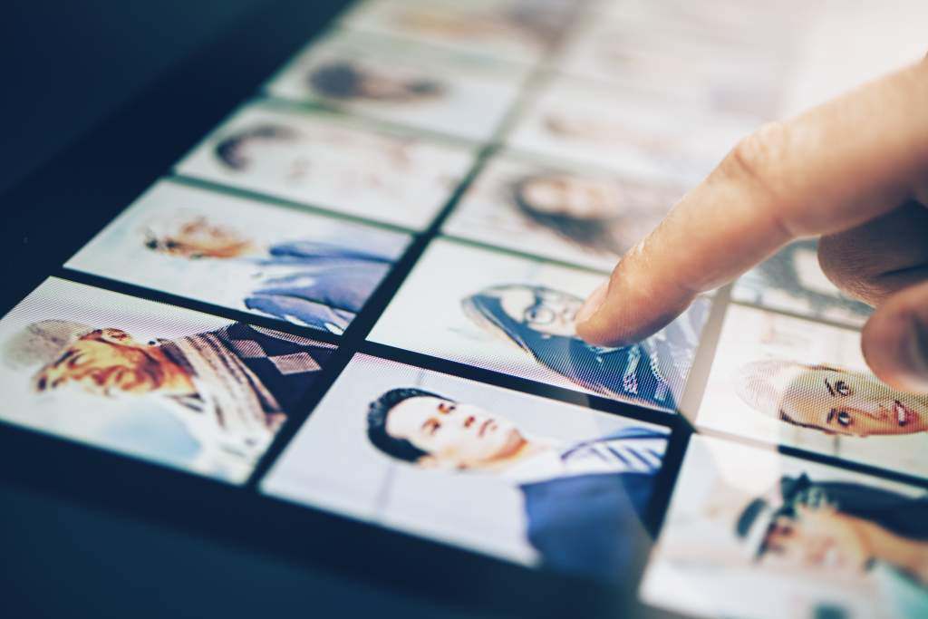 Man’s finger flips through his digital photo album, preparing to make a photo book on iPad.