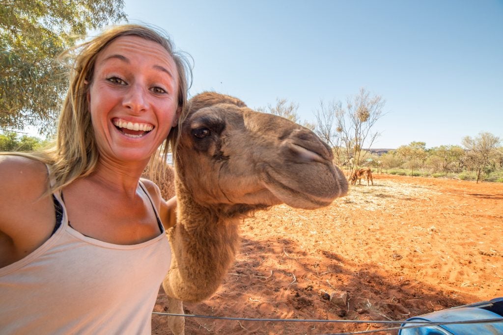 Fun photo ideas include animals, like this woman taking a selfie with a camel in the desert.  