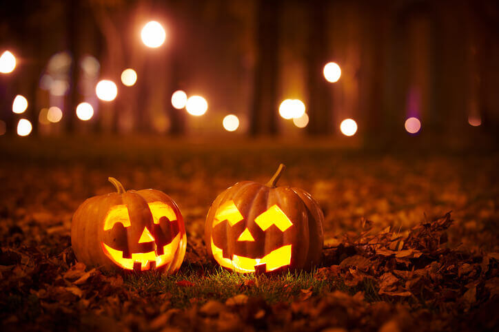 The best Halloween photoshoot ideas might include 2 jack-o-lanterns lit up at night in the woods.