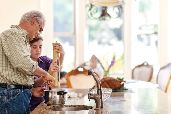 Thanksgiving pictures should capture little boy with peppercorn mill helping Grandpa cook.