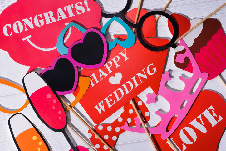 A wedding photo booth uses fun props to liven up photos. 