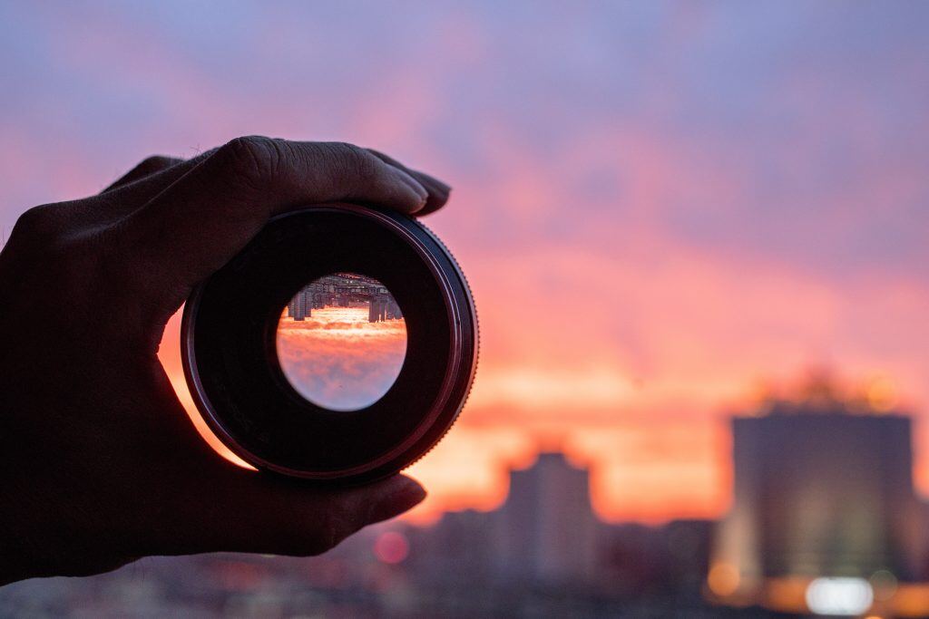 Use the right camera lens to capture nature photography, like this sunset over a city skyline.