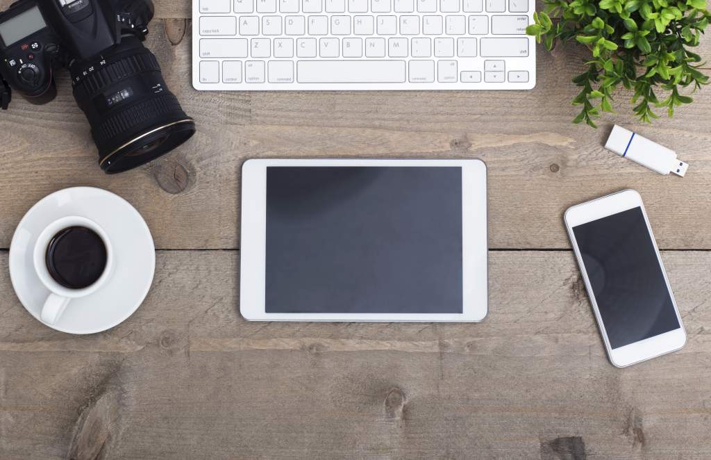 A photographer’s camera and Apple devices on the desk illustrate how to convert iPad photos to JPEG.