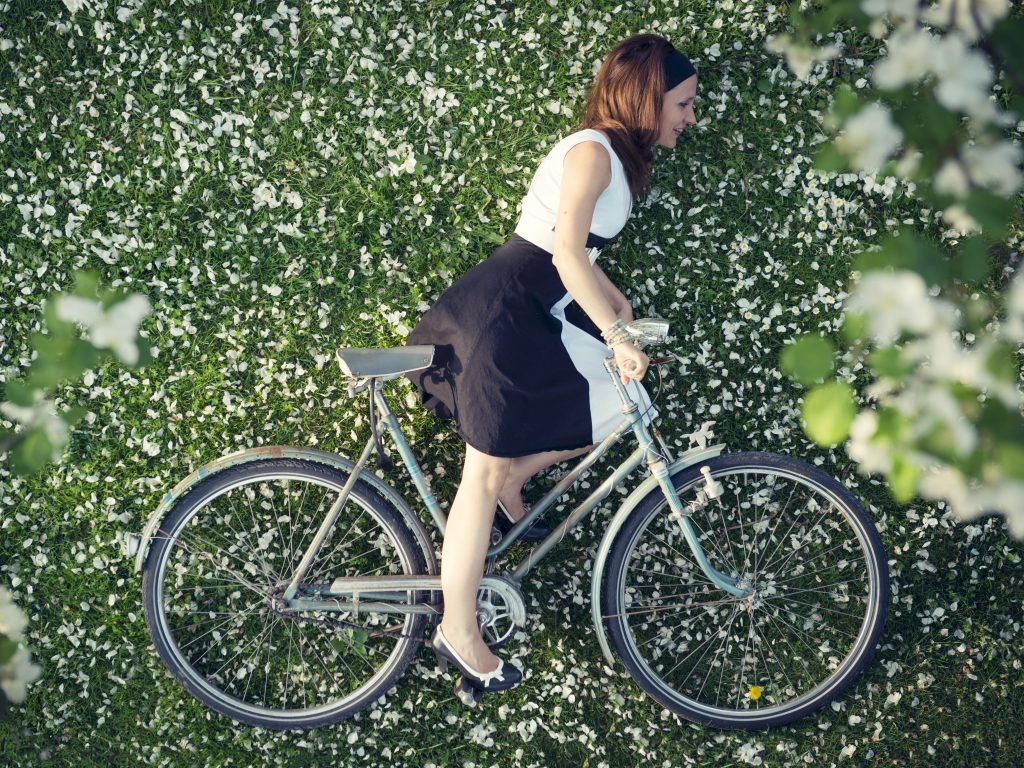 Overhead shot of woman in skirt on bicycle appears flat, a force perspective photography idea.