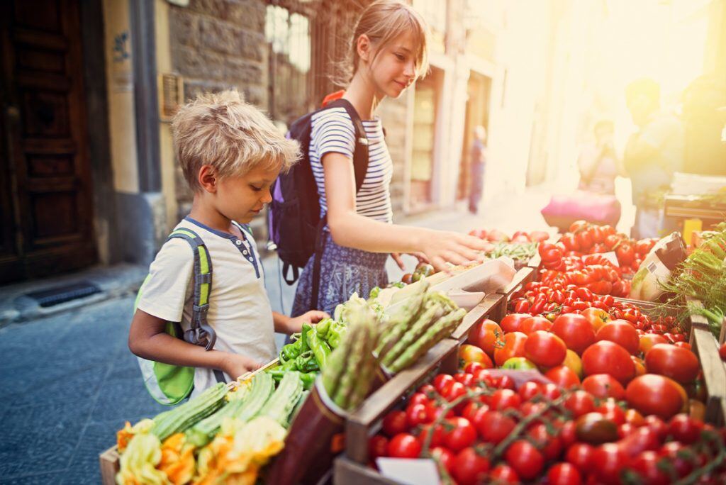 A young boy and girl looking at fresh vegetables | Motif