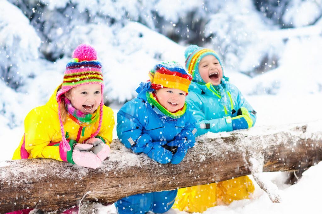 Kids in Colorful Coats Contrasted Against Snowy Backdrop