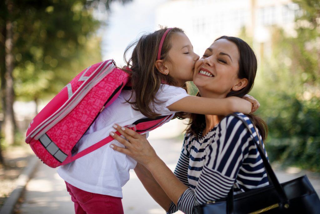 Mom gets a kiss before dropping daughter off at school | Motif