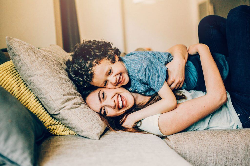 A mother and son playing on a couch | Motif