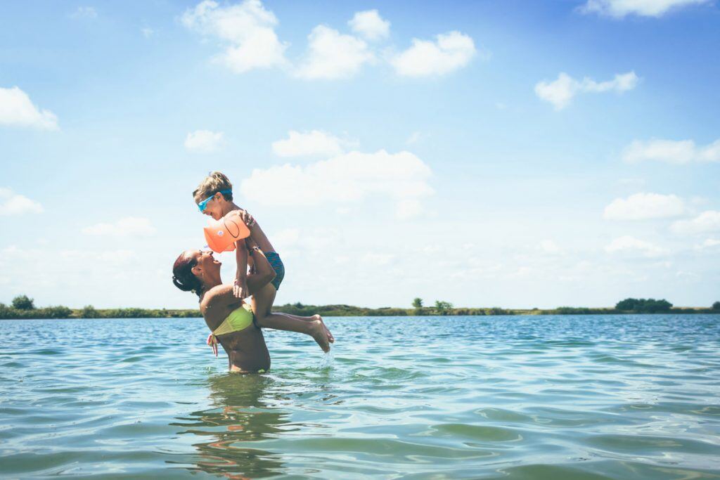 Mother and toddler-age son playing in the water