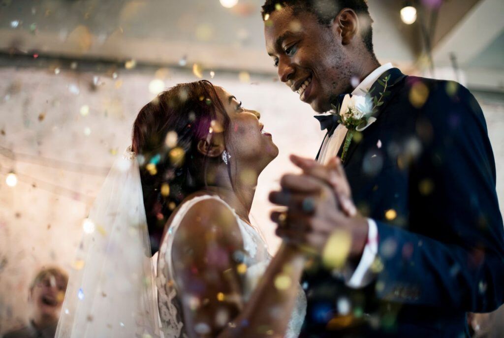 A bride and groom dancing at their wedding reception | Motif