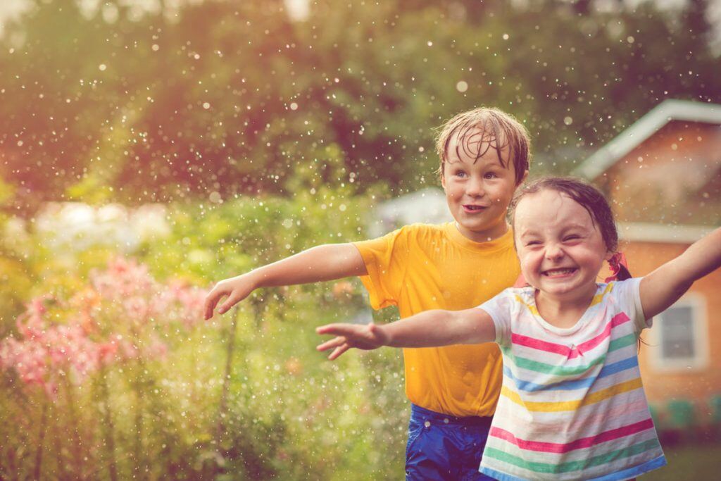 Photography of two kids running through the water at a BBQ | Motif