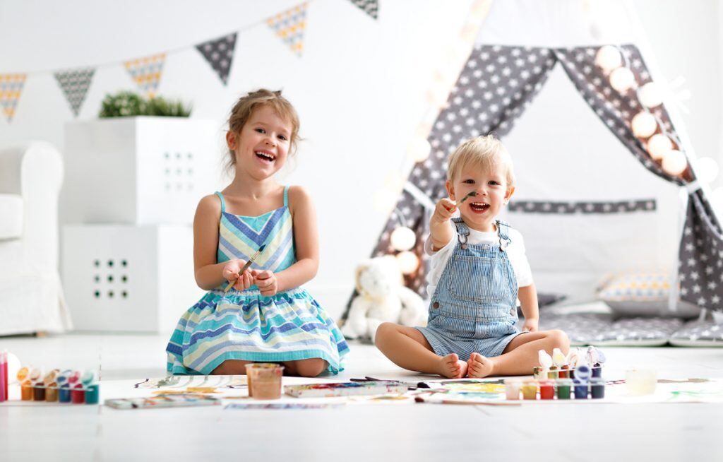 Two children painting in their playroom | Motif