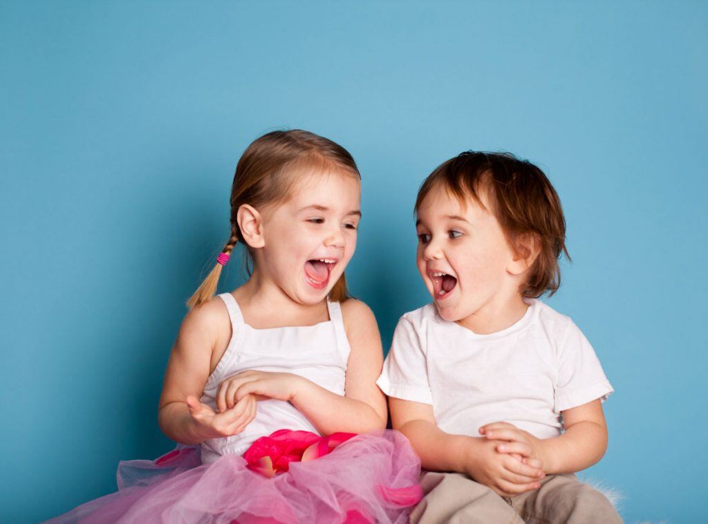 Two kids laughing while getting their picture taken | Motif