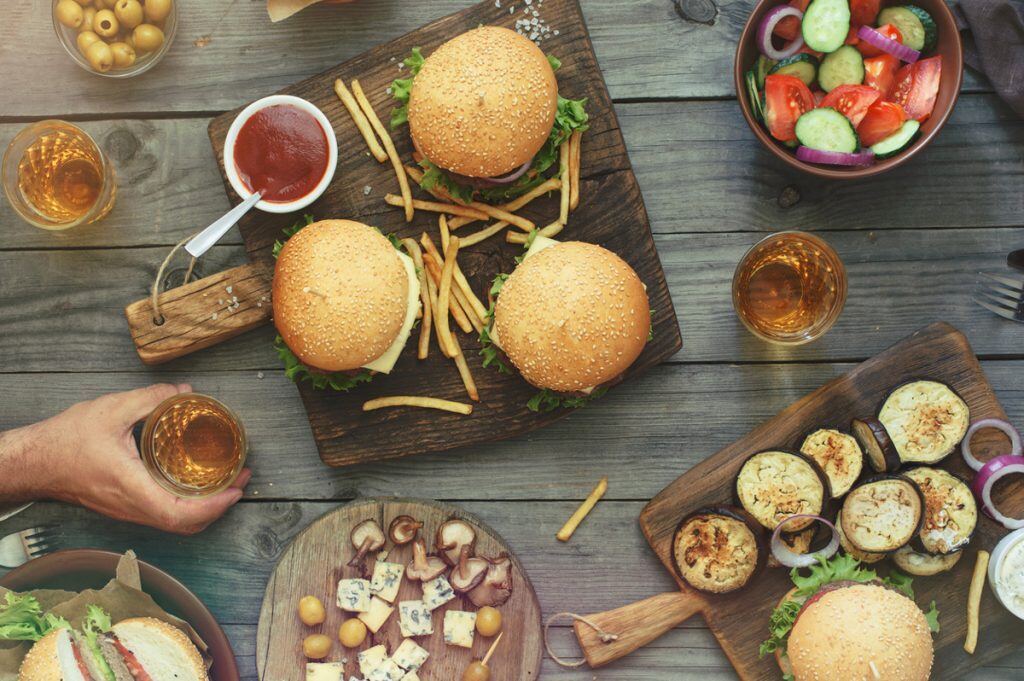 Photography of burgers, salad, sandwiches, and other food on a table | Motif