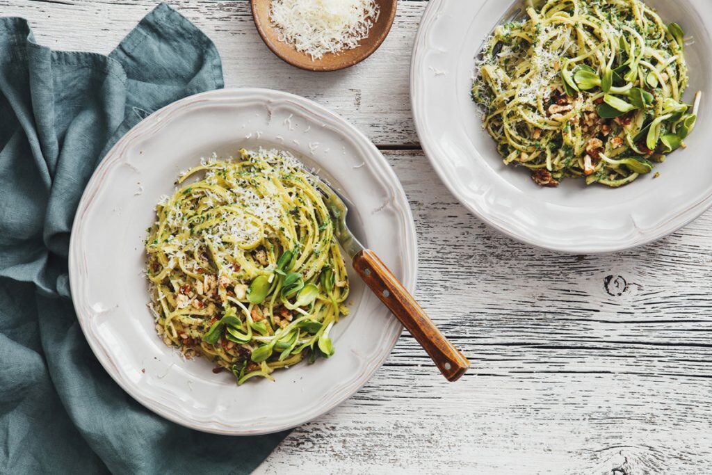 Two plates of pasta on a wooden table | Motif